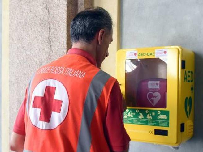 operatore della croce rossa che guarda un defibrillatore