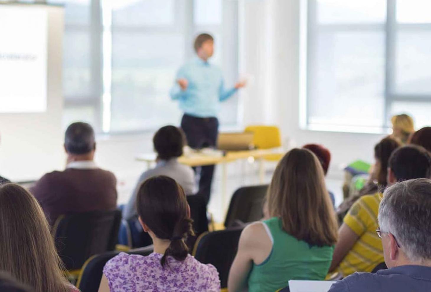 Docente che parla davanti a diverse persone