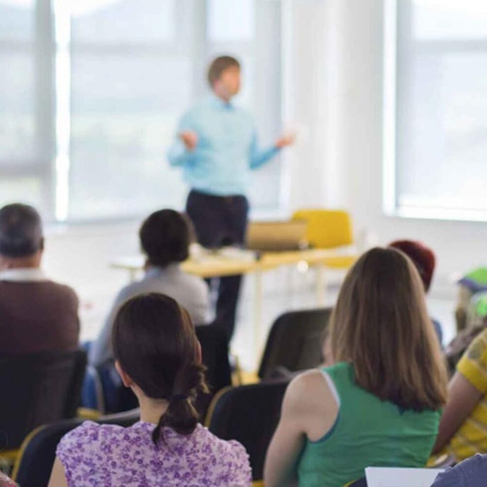 Docente che parla davanti a diverse persone